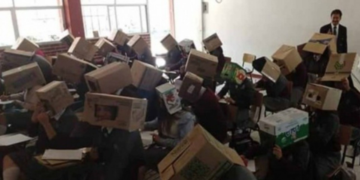 Maestro evita copiones en examen con cajas en la cabeza de sus alumnos