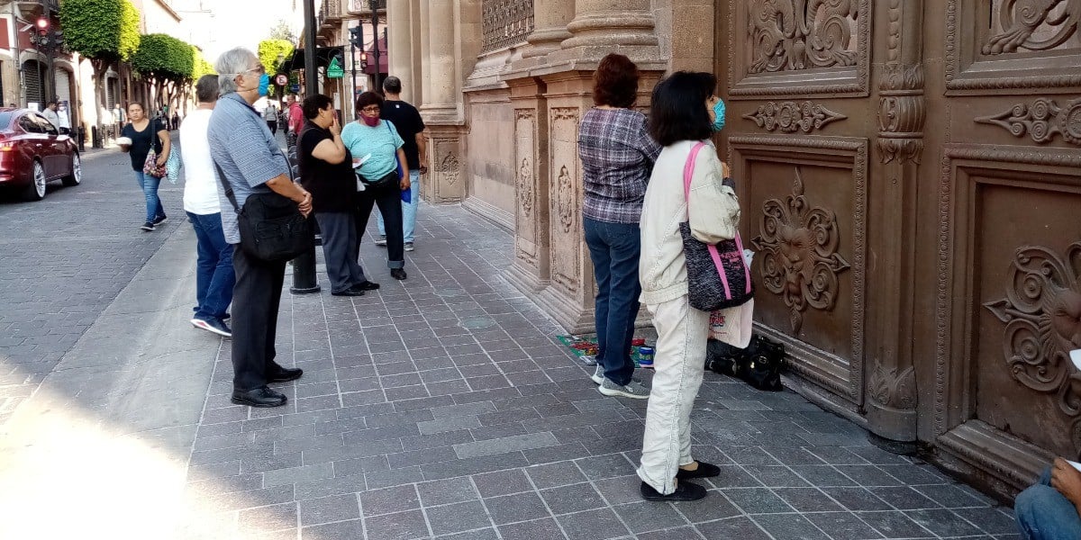 Feligreses le rezan a la virgen en el exterior de la Catedral, ignorando el exhorto de la Iglesia