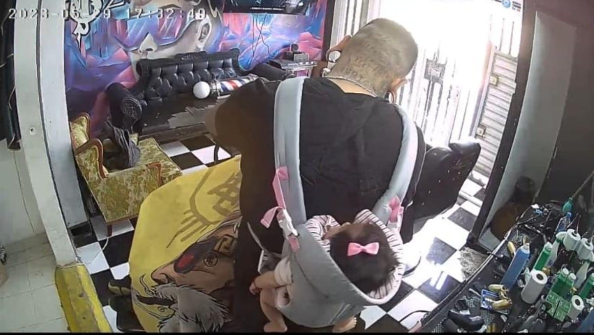 ¡El mejor look! Barbero carga con su bebita mientras trabaja