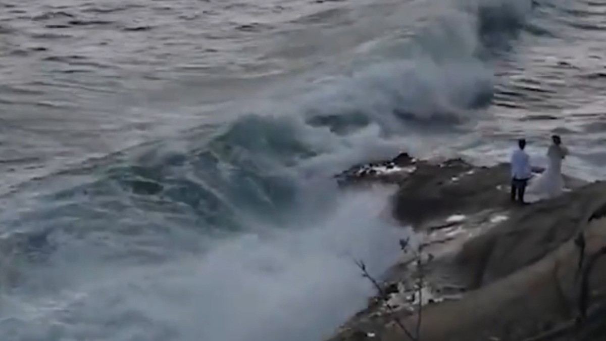 VIDEO Enorme ola se traga a una pareja de novios durante su sesión de fotos
