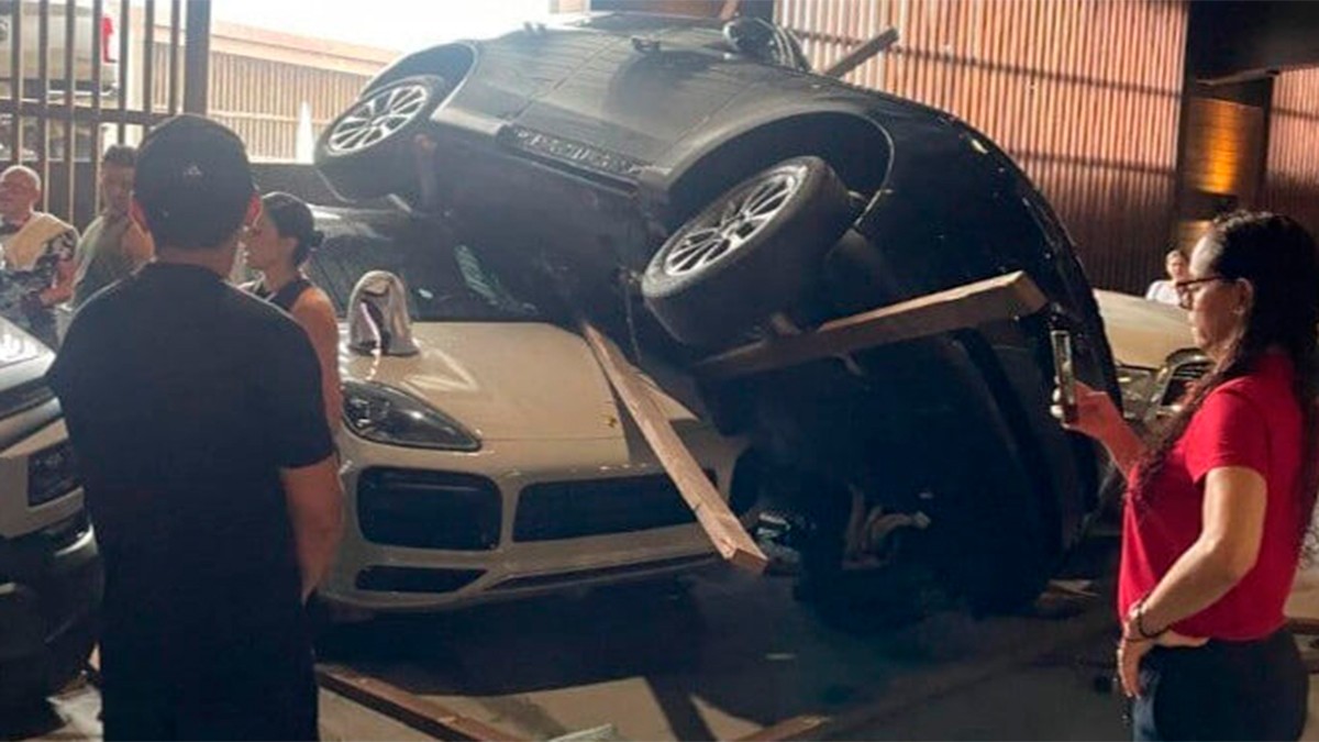 Mujer confunde pedal y su camioneta cae de rampa de estacionamiento sobre un carro de lujo