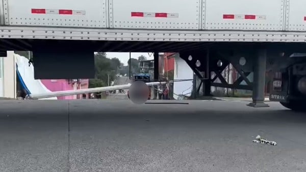 Tráiler tira poste de luz y este le cae a un motociclista y lo mata