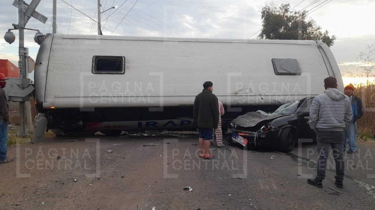 Chofer de camión intenta ganarle el paso a tren, pero lo avienta ¡y cae sobre un Chevy!