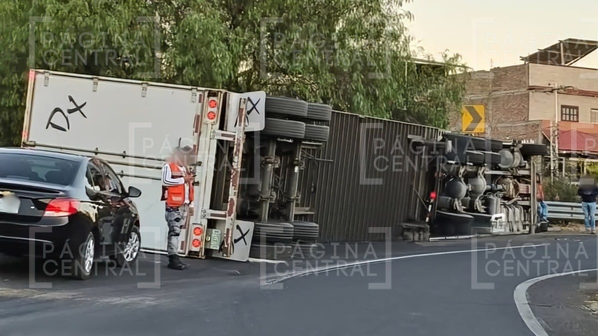 ¡Le ganó la carga! Tráiler sufre volcadura en curva del distribuidor y causa caos vial
