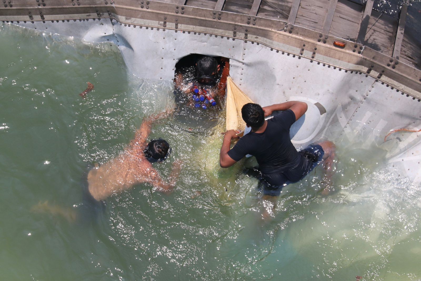 Mientras conductor moría: Cae tráiler a río y civiles bucean para hacer rapiña