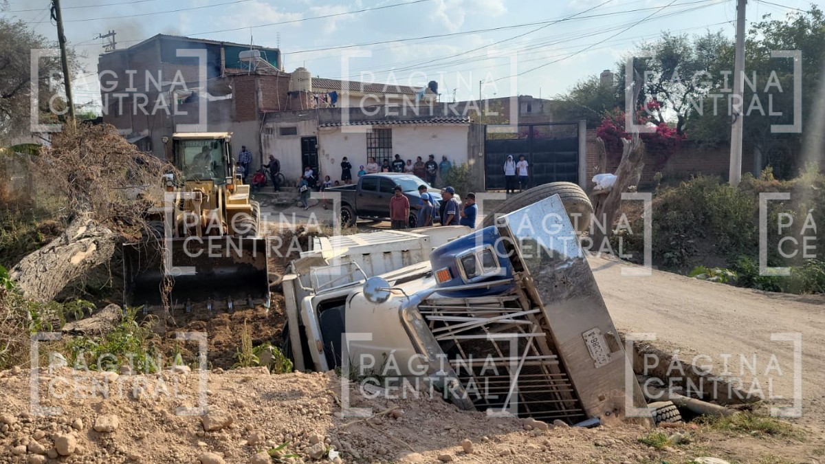 Tolva cargada con material intenta cruzar un puente angosto y termina volcada en un arroyo