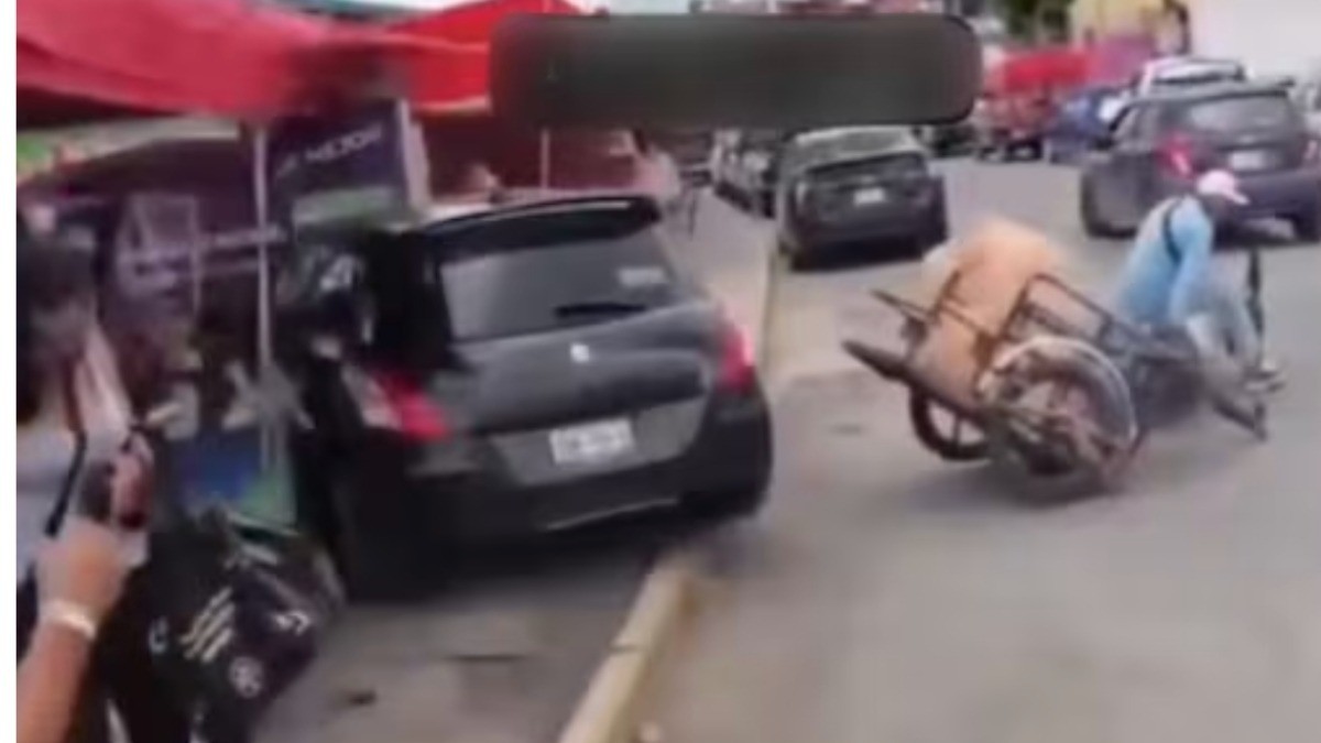 VIDEO Conductora atropella puestos de tianguis en medio de pelea con motociclista