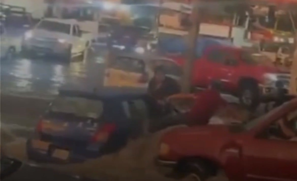 VIDEO Hombre hace malabares para salvar a mujer en ‘diluvio’, terminan abrazados en un cofre