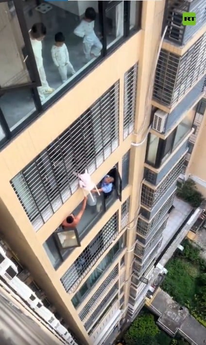 Niña colgando de un edificio