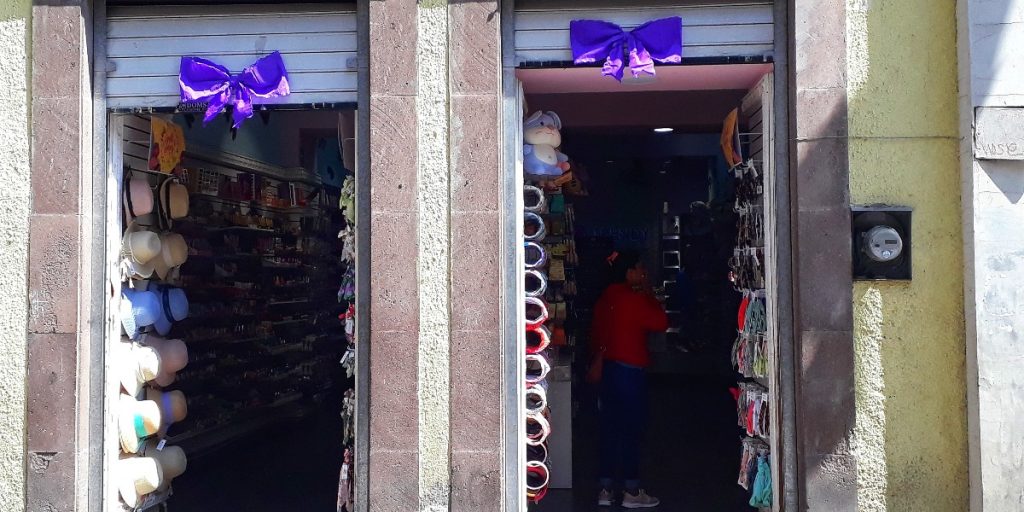 Algunos comercios colocaron moños morados en sus fachadas