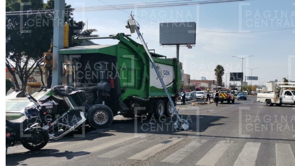 Camión recolector sin frenos se sube a camellón y tumba 2 postes